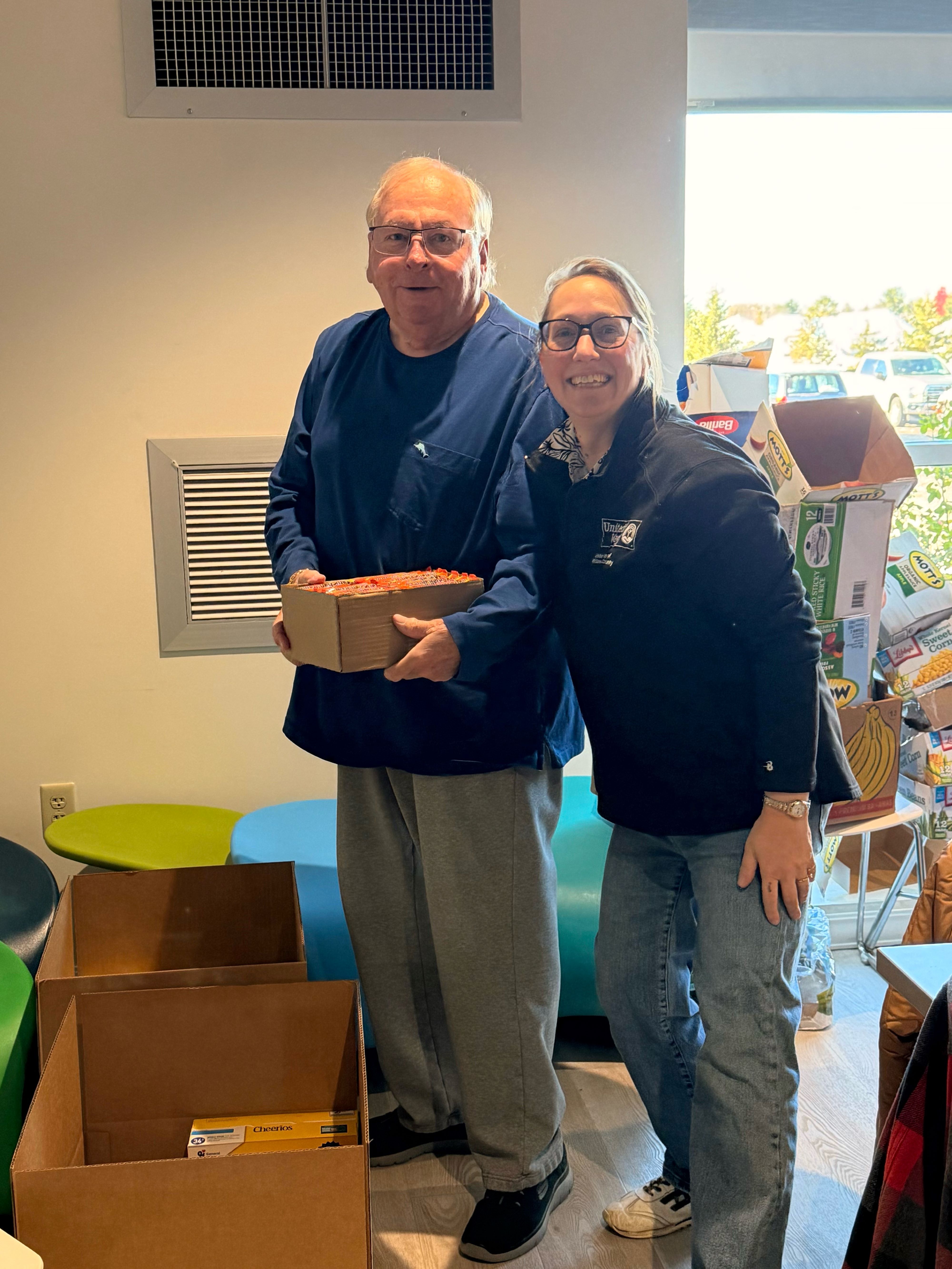 United Way Board member Tom Reed(L) and Executive Director Amy Kirby(R) fill boxes for those in need.